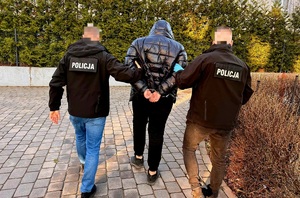 Policjanci prowadzą zatrzymanego.