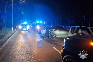 Noc. policjanci podczas kontroli drogowej przeszukują bagażnik. Żółte paczki.