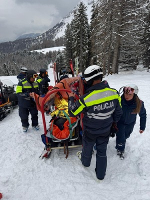 Policjanci zabezpieczają osobę poszkodowana na stoku narciarskim.