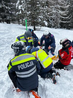 policjanci udzielają pomocy poszkodowanemu.