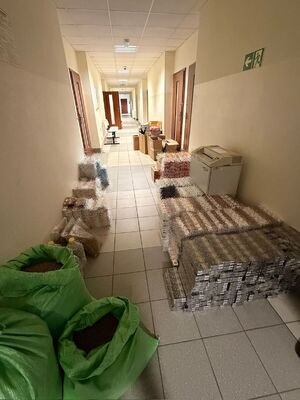 Zabezpieczone nielegalne papierosy ułożone na korytarzu.