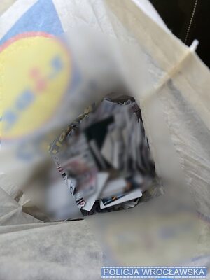 na stole porozkładane karty sim, telefony, w reklamówkach, widać telefony i pieniądze.