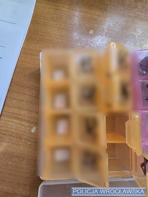 na stole porozkładane karty sim, telefony, w reklamówkach, widać telefony i pieniądze.