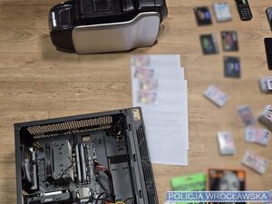 na stole porozkładane karty sim, telefony, w reklamówkach, widać telefony i pieniądze.