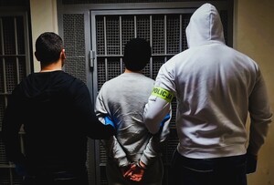 policjant prowadzą zatrzymanego.