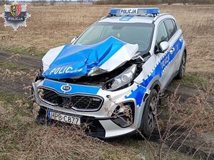 rozwalony radiowóz stoi na polu.