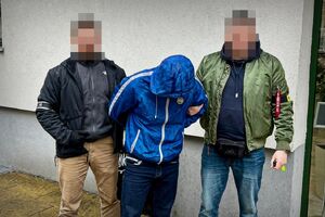dwóch nieumundurowanych policjantów prowadzi zatrzymanego.