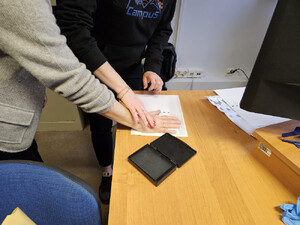 Policjant pobiera odciski palców od zatrzymanego.