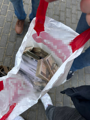 zatrzymany leży na ziemi. pilnuje go policjant.