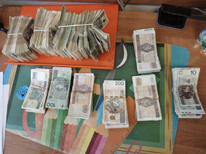 zatrzymany leży na ziemi. pilnuje go policjant.