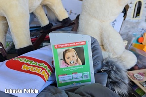 Na pierwszym planie skarbonka z wizerunkiem 4-letniej Laury,  w tle dwie maskotki.