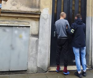 policjant idzie z zatrzymanym.