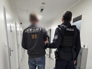 policjant stoi z zatrzymanym.