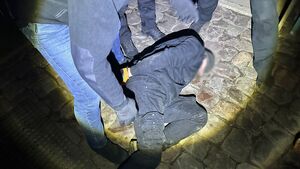 zatrzymany leży na ziemi, jest skuty w kajdanki.