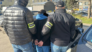 Dwaj policjanci prowadzą mężczyznę.