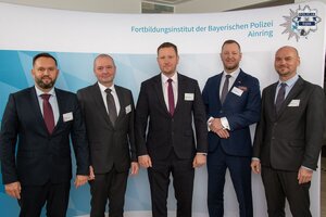 Pięciu mężczyzn w garniturach pozuje do zdjęcia.