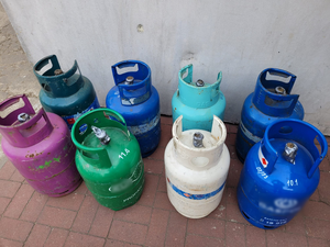 Policjanci prowadzą zatrzymanych. Kable porozkładane na ziemi w pudełkach i kartonach.