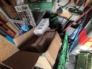 Policjanci prowadzą zatrzymanych. Kable porozkładane na ziemi w pudełkach i kartonach.