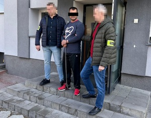 Policjanci prowadzą zatrzymanego.