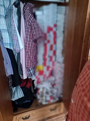 Nielegalne papierosy wśród ubrań w szafie.