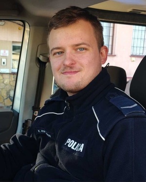 policjant pozuje do zdjęcia.