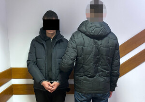 Policjant prowadzi zatrzymanego.