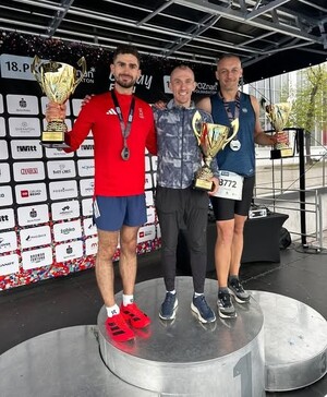 Najlepsi zawodnicy na podium prezentują puchary.