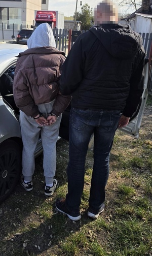 policjant stoi z zatrzymaną.