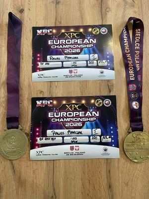 Dwa medale i kartki z nazwiskiem zwycięzcy.