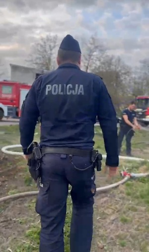 Odwrócony tyłem policjant.