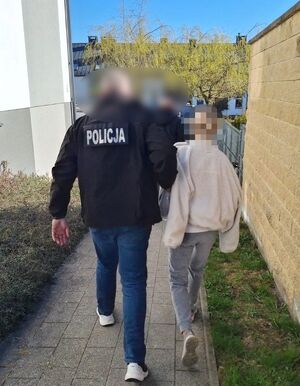 Policjant prowadzi zatrzymaną.