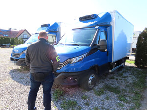 Policjant stoi przy autach.