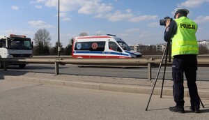 Zdjęcie przedstawia funkcjonariusza Policji z laserowym miernikiem prędkości