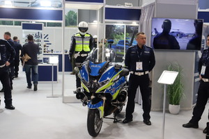 Zdjęcie przedstawia funkcjonariusza Policji wraz z motocyklem