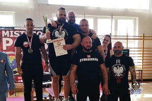 Ludzie na podium z pucharami i medalami.