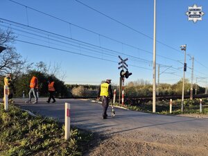 Policjant zabezpiecza ślady zdarzenia specjalnym wózkiem do mierzenia odległości.
