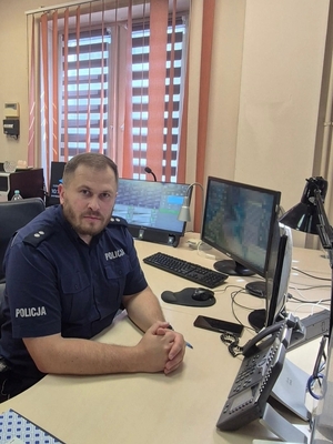 policjant siedzi przy biurku.