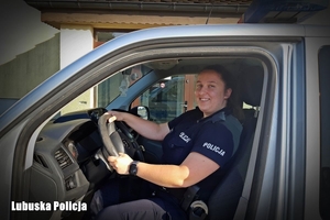 policjantka siedzi za kierownicą radiowozu.