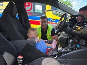 Na zdjęciu dziecko w aucie i policjant.