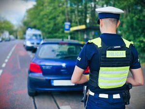 policjanci prowadzą zatrzymanego.