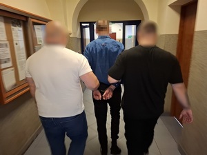 Policjanci prowadzą zatrzymanego.