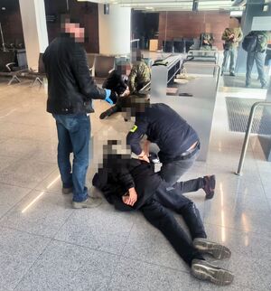 Funkcjonariusze z zatrzymanymi, którzy leżą na ziemi.
