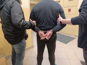 Zatrzymany prowadzony przez policjantów.