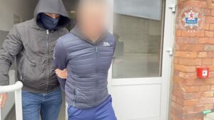 Zatrzymany prowadzony przez policjanta.
