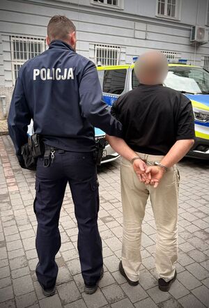 Zatrzymany prowadzony przez policjanta.