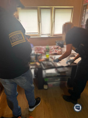 Troje policjantów przy stole na którym leżą różnego rodzaju dokumenty.