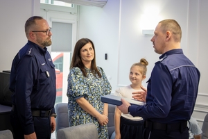 Uczestnicy spotkania w KGP. Policjant z rodziną oraz policjanci z komendantem głównym Policji na czele.