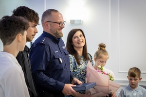 Uczestnicy spotkania w KGP. Policjant z rodziną oraz policjanci z komendantem głównym Policji na czele.