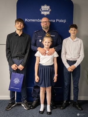 Policjant z dwoma synami i córką pozuje do zdjęcia.