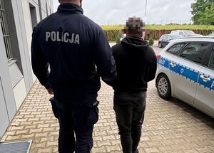 Zatrzymany prowadzony przez policjanta.